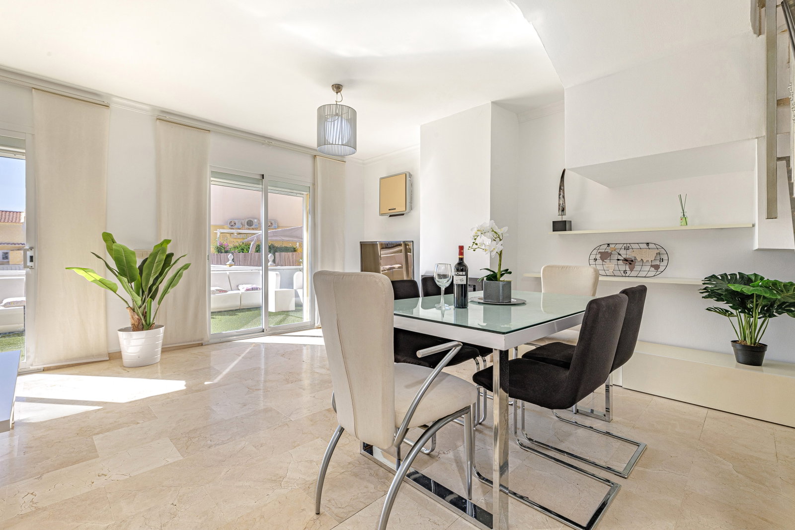 Sunlight fills this modern dining space. Sliding glass doors open directly to a bright private terrace.